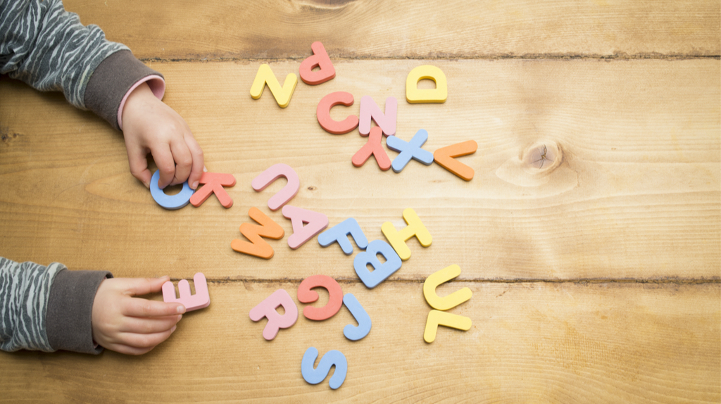 Child playing with scattered alphabets
